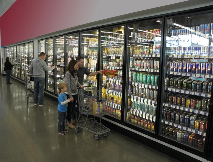 Customers browsing merchandise in a display walk-in commercial refrigerator